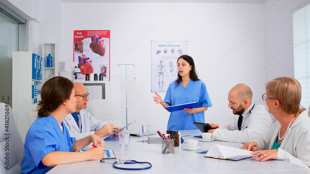 Attentive medical team discussing medicine problems, doctors with tablet pc and clipboards working in meeting hospital office. Brainstorming ideas, physicians diagnosis using modern technology Attentive medical team discussing medicine problems, doctors with tablet pc and clipboards working in meeting hospital office. Brainstorming ideas, physicians diagnosis using modern technology