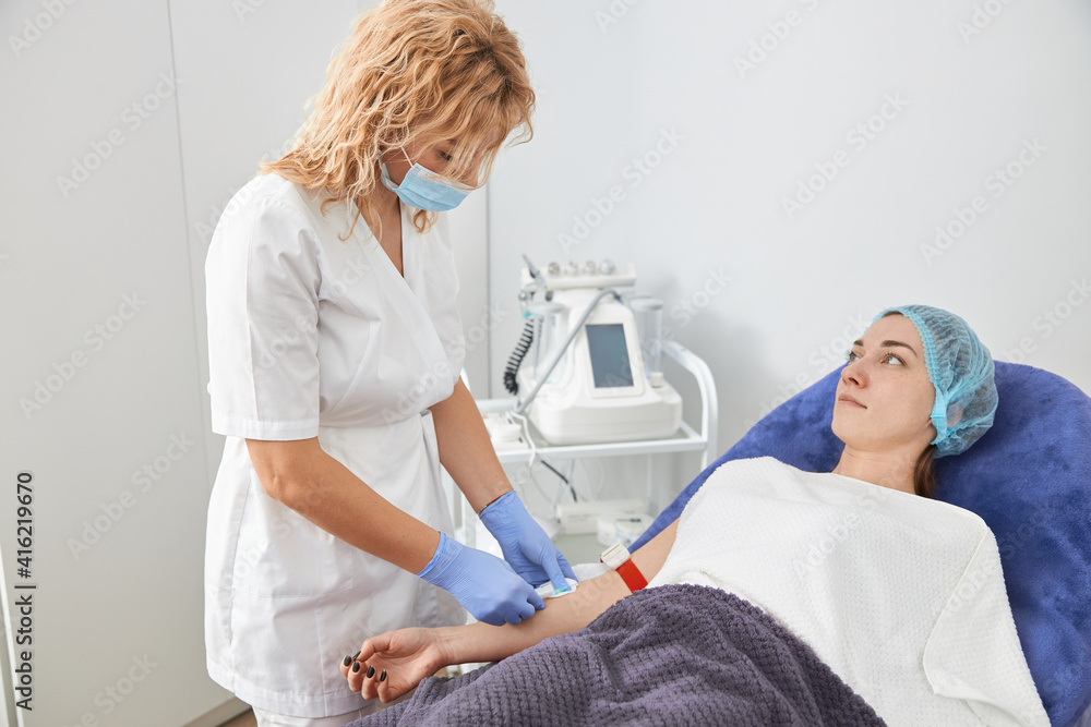 Professional cosmetologist is doing procedures for client in light cabinet Professional cosmetologist is doing procedures for client in light cabinet