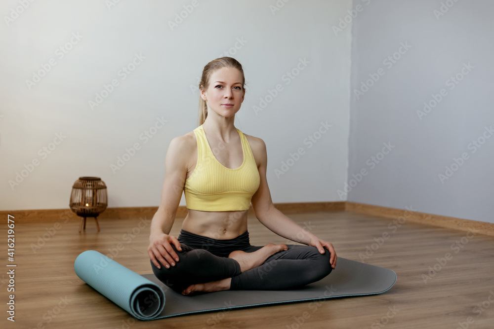 A blonde girl is resting after a fitness class and meditating. The concept of sports and a healthy lifestyle. Yoga, meditation A blonde girl is resting after a fitness class and meditating. The concept of sports and a healthy lifestyle. Yoga, meditation