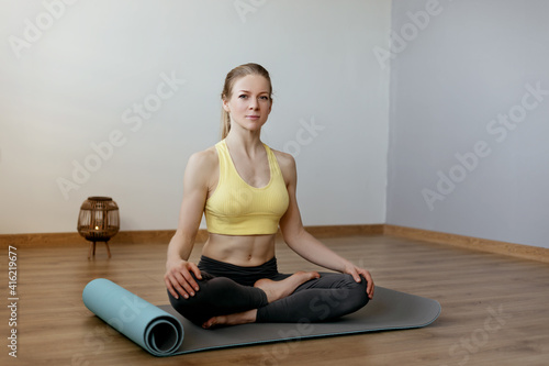 A blonde girl is resting after a fitness class and meditating. The concept of sports and a healthy lifestyle. Yoga, meditation