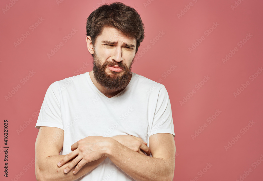Sad man crossed his arms over his chest on a pink background Sad man crossed his arms over his chest on a pink background