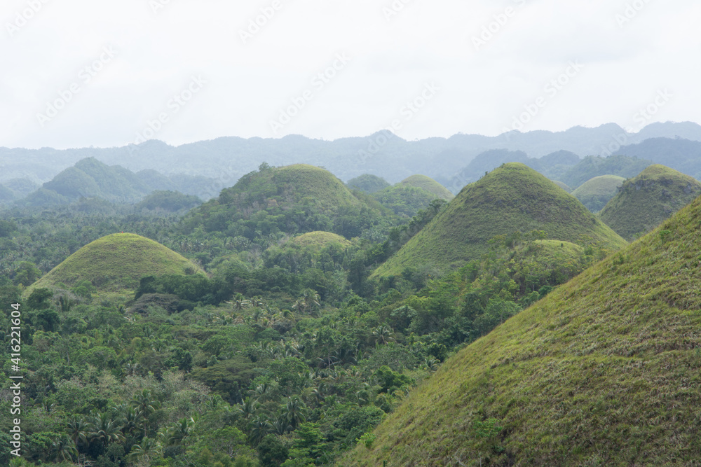 Chocolate Hills with a group of clouds in the sky Chocolate Hills with a group of clouds in the sky