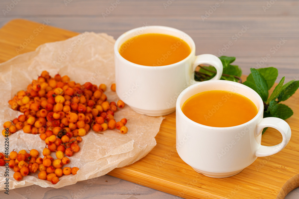 Sea buckthorn tea served on wooden table Sea buckthorn tea served on wooden table