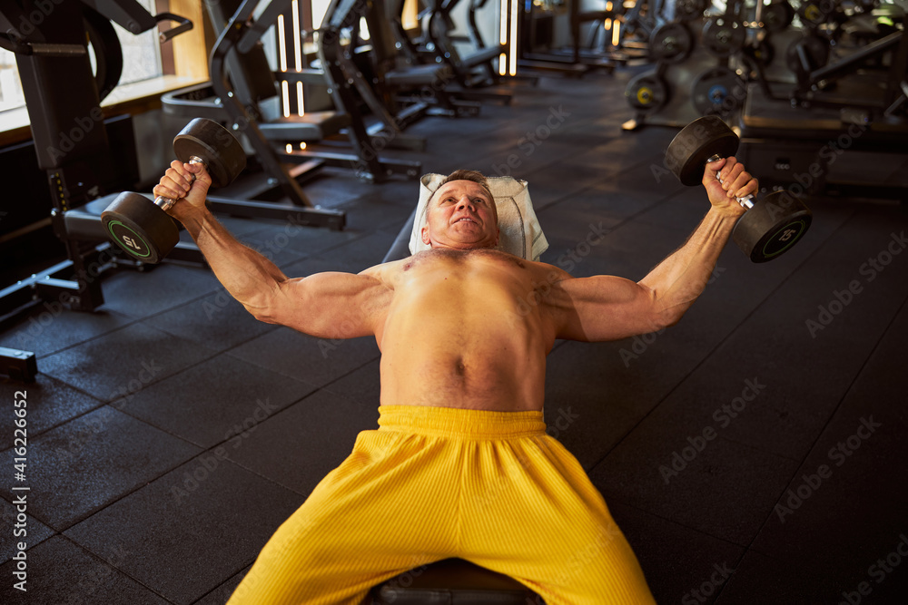 Naklejka premium Hefty sportsman having a proper dumbbell workout