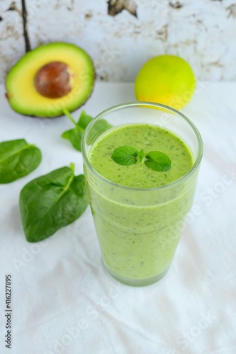 Green smoothie made from spinach , banana, avocado, soy milk and lime juice