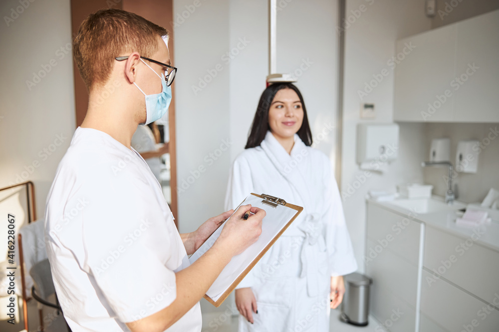 Obraz premium Pleased patient having her height measured at the doctor office