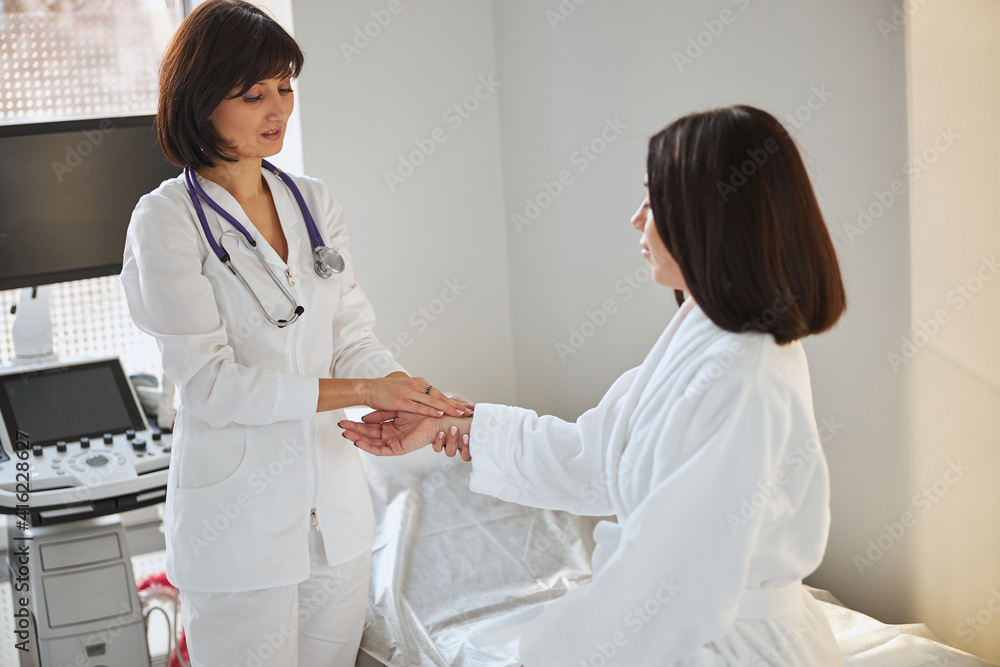 Experienced cardiologist checking the patient heart rate Experienced cardiologist checking the patient heart rate