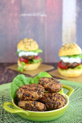 Beluga lentil rice patties with vegetarian burger on the background