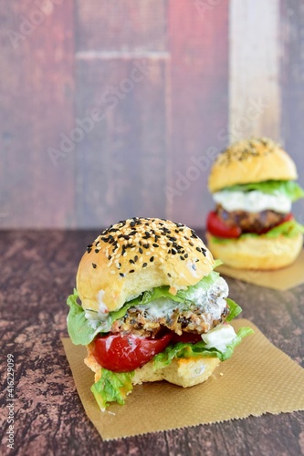 Vegetarian burger. Sesame bread bun with lentil patty, tomato, lettuce and yogurt