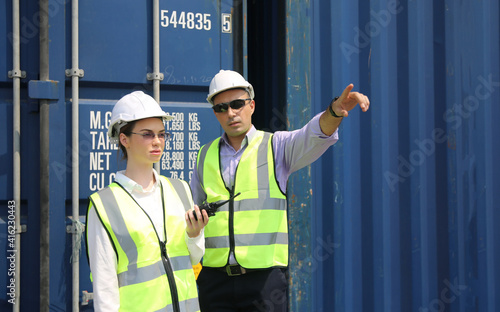 Logistics engineer control at the port, loading containers for trucks export and importing logistic concept