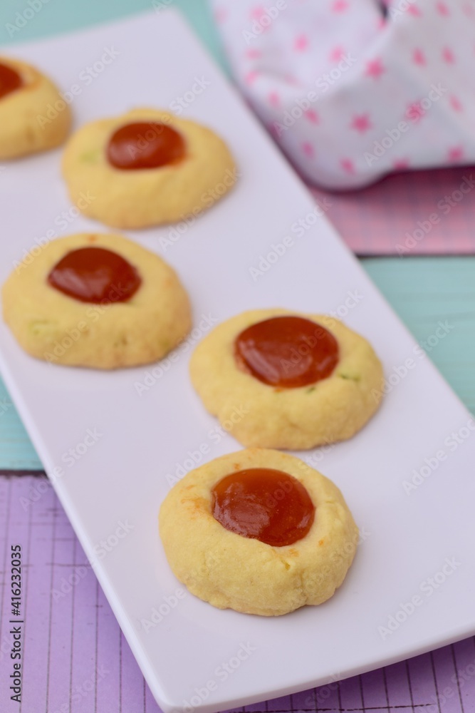 Homemade thumbprint cookies with jam on white serving plate. pastel color background
Homemade thumbprint cookies with jam on white serving plate. pastel color background
