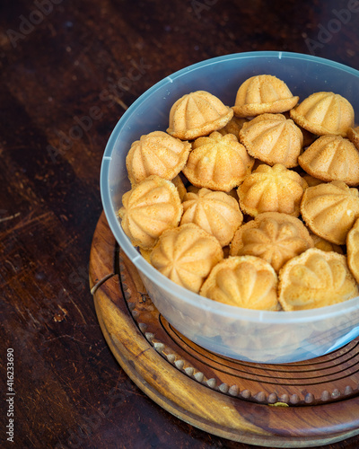 Kuih Bahulu, baulu or bolu in a container. Sponge cake baked in special aluminium moulds is the Asian tradition food in popular Malaysia and Indonesia. photo