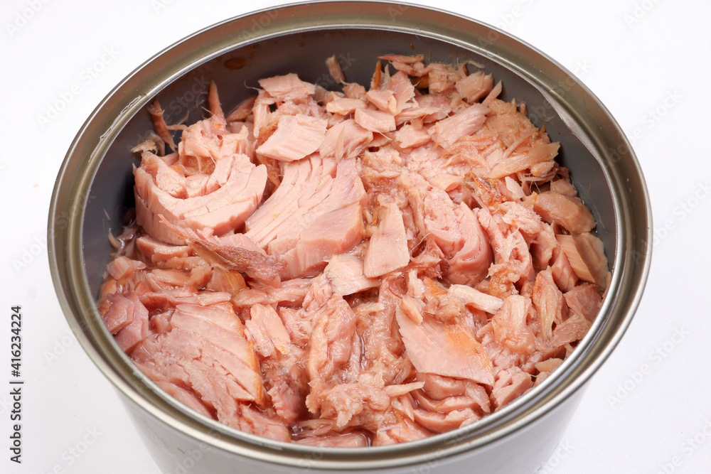 Tuna fish meat flaky chunk in tin can on white background Tuna fish meat flaky chunk in tin can on white background
