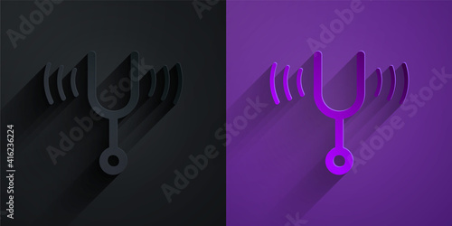 Paper cut Musical tuning fork for tuning musical instruments icon isolated on black on purple background. Paper art style. Vector.