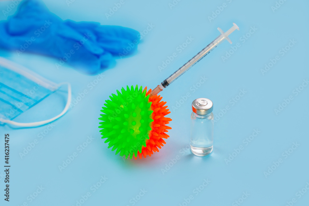 Vaccines and syringes, face mask on blue background. Vaccines and syringes, face mask on blue background.