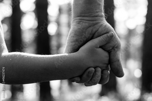 Close-up hands, father with son in the Park. Black and white photo.