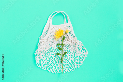 White eco bag mesh texture with flower on blue background.