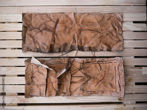 Vászonkép Leather pouch made of zombie skin with scars stitched with brown thread top view