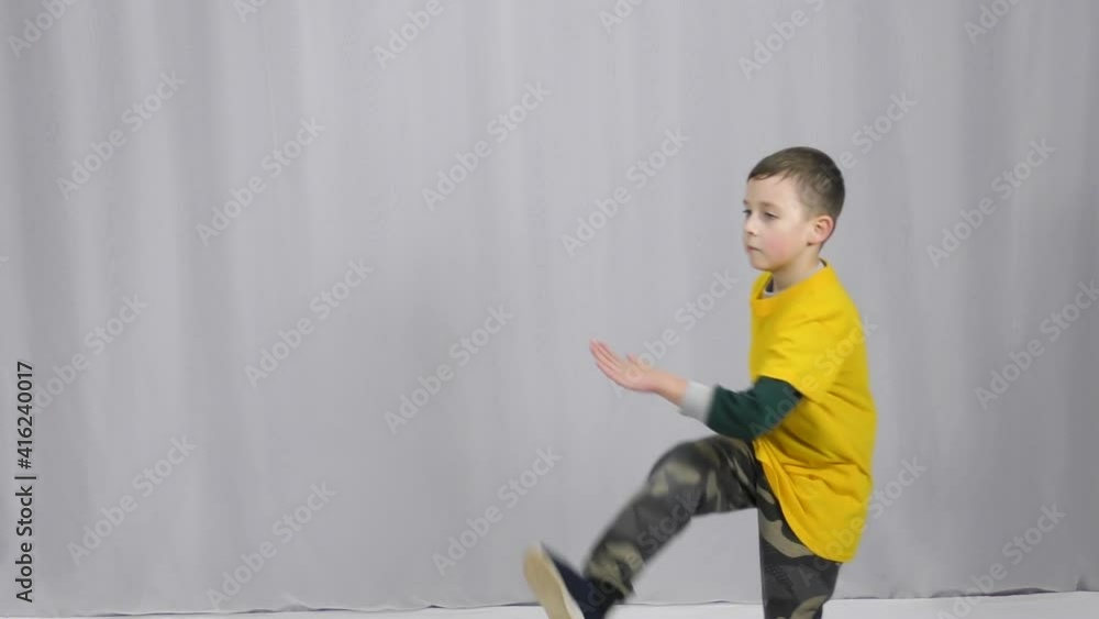 An athlete in a yellow T-shirt makes movement in a standing position and punches in a jump An athlete in a yellow T-shirt makes movement in a standing position and punches in a jump