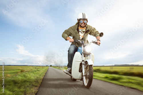 Funny biker riding a moped with his dog