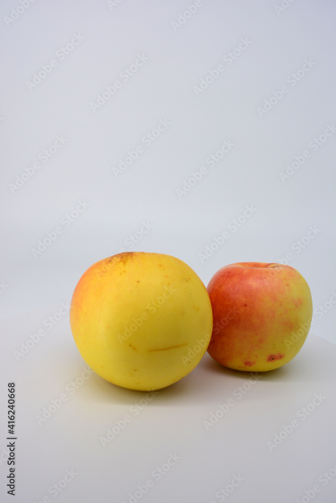 Small ripe yellow apples with red sideways located on a white background. Small ripe yellow apples with red sideways located on a white background.