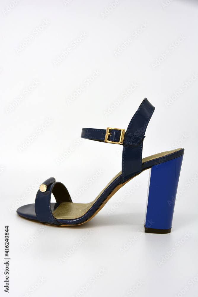 One thing, one pair of female blue lacquer sandals on a wide heel with a golden insole located on a white background. One thing, one pair of female blue lacquer sandals on a wide heel with a golden insole located on a white background.