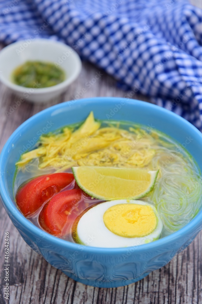 Soto Ayam, traditional Indonesian soup made from broth, chicken, egg, vermicelli and vegetables. Served with sambal green chili Soto Ayam, traditional Indonesian soup made from broth, chicken, egg, vermicelli and vegetables. Served with sambal green chili