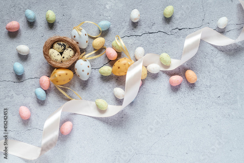 Easter background with colourful Easter eggs with bird's nest and pink satin ribbon withc copy space photo