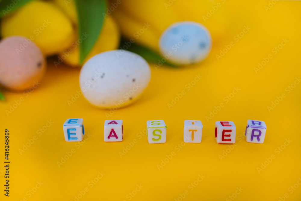 Easter holiday decorations on yellow background Colorful easter painted speckled eggs in basket. Traditional Spring composition Easter elements flowers and eggs for springtime easter greeting card