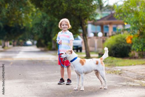 Child walking dog. Kids and puppy. Boy and pet. photo