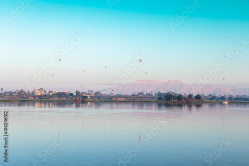 many hot air balloons floating over the Nile River in Luxor at sunrise  © Mostafa Eissa