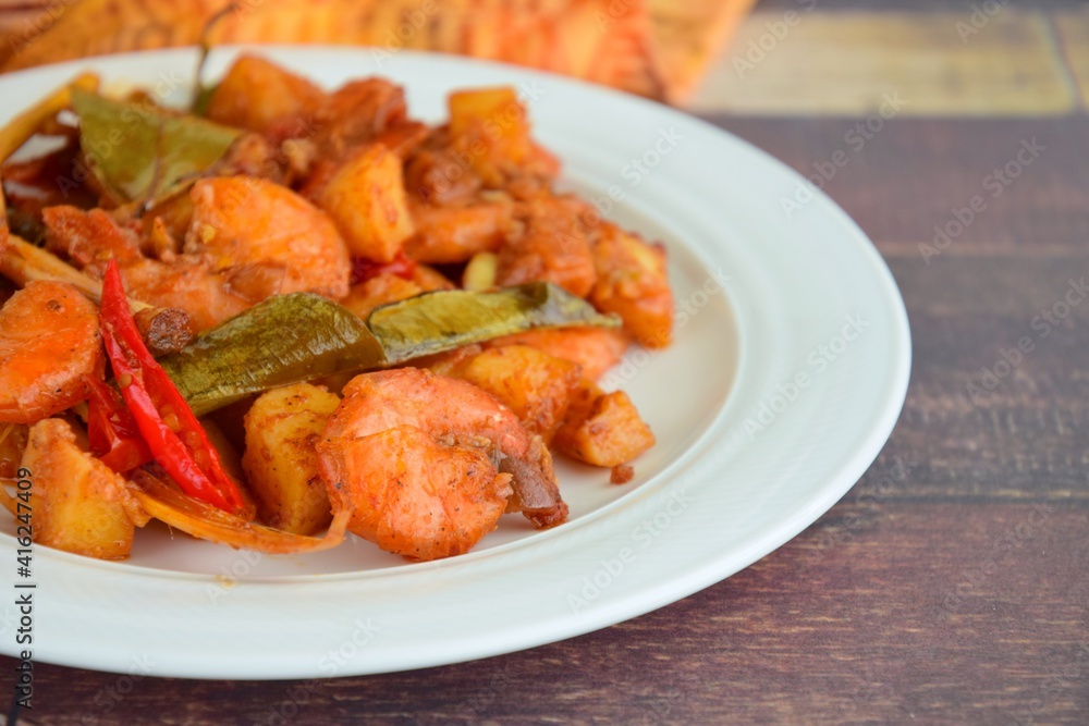 Sambal goreng kentang udang. Fried cubed potato with prawns cooked with coconut milk and spices (Indonesian food)