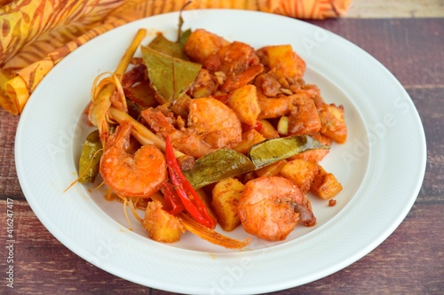 Sambal goreng kentang udang. Fried cubed potato with prawns cooked with coconut milk and spices (Indonesian food)