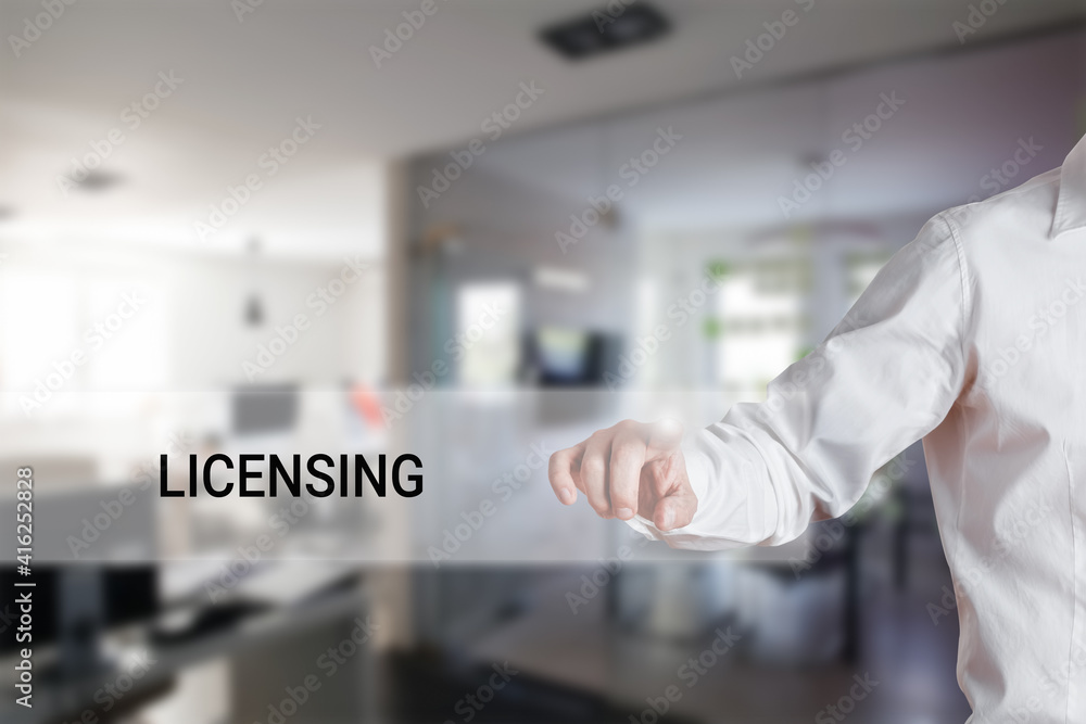 Male hand pressing the word licensing on a virtual search display bar. Male hand pressing the word licensing on a virtual search display bar.