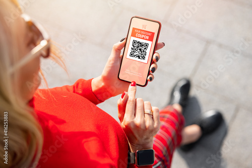 Woman viewing discount coupon on mobile phone
