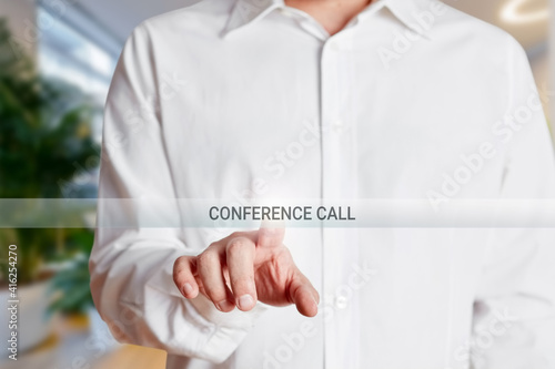 Businessman presses conference call button on a virtual screen. photo