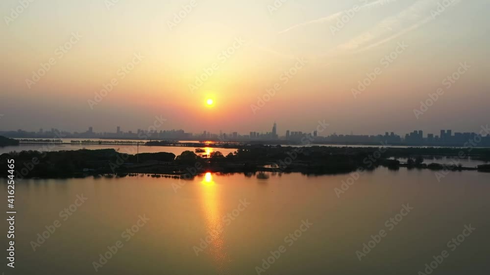 The view of distant city and the beautiful lake with sunset in the water The view of distant city and the beautiful lake with sunset in the water