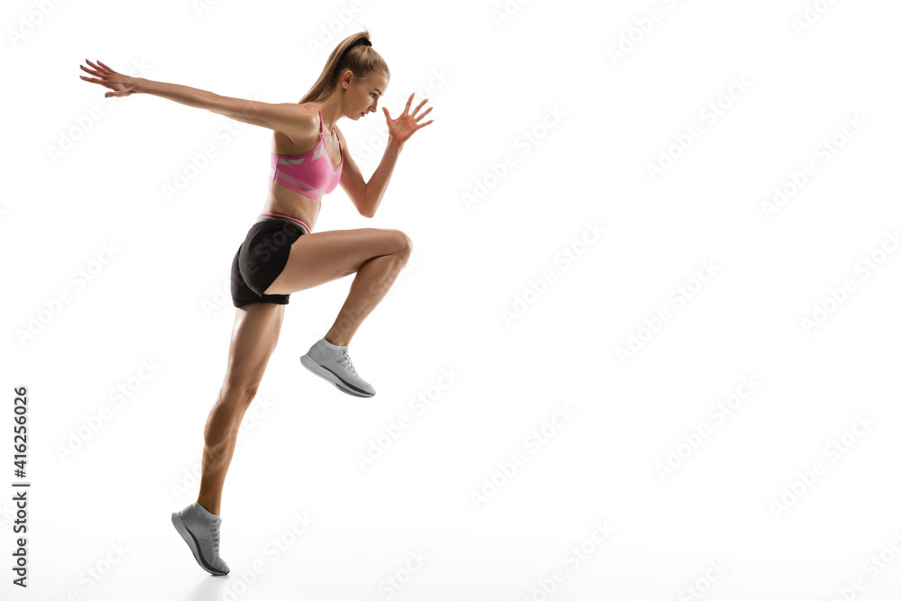 In air. Caucasian professional female athlete, runner training isolated on white studio background. Muscular, sportive woman. Concept of action, motion, youth, healthy lifestyle. Copyspace for ad.