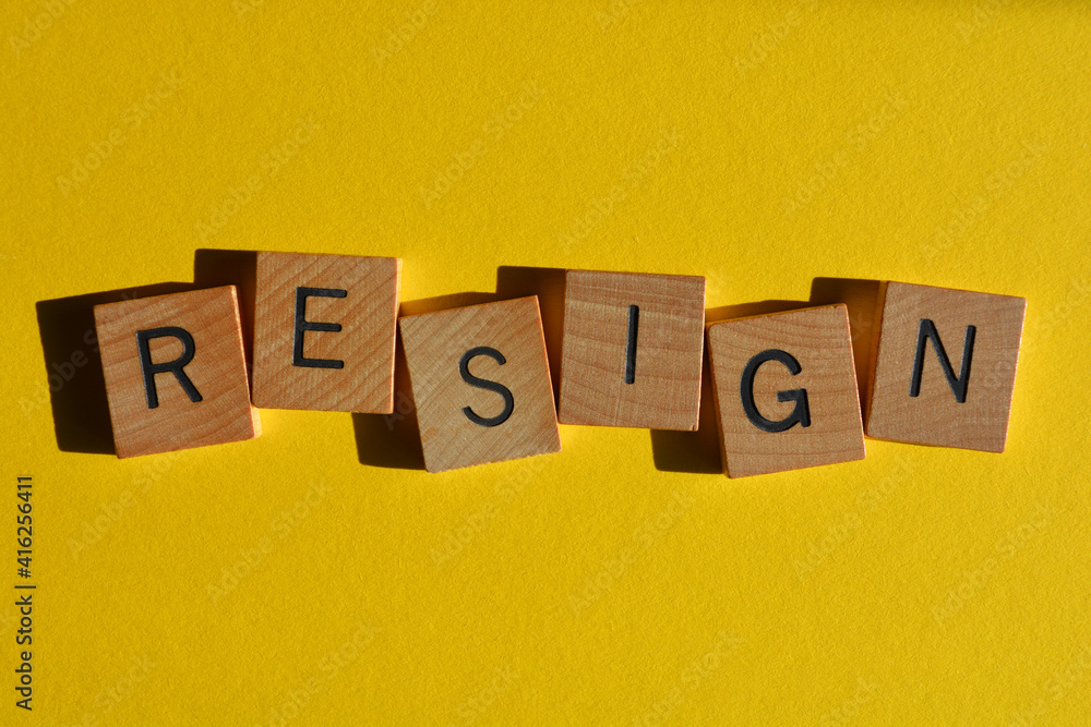 Resign, word in wooden alphabet letters isolated on yellow Resign, word in wooden alphabet letters isolated on yellow