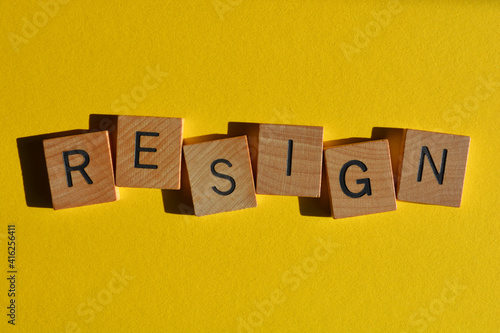 Resign, word in wooden alphabet letters isolated on yellow