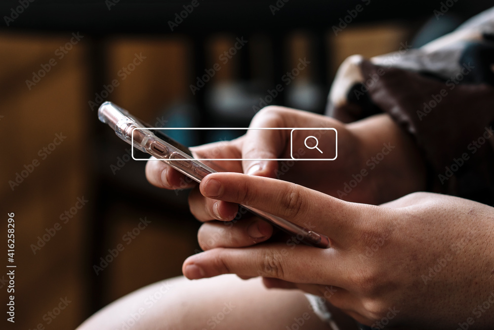 Woman's hands looking at the phone with search bar in the center of the image Woman's hands looking at the phone with search bar in the center of the image