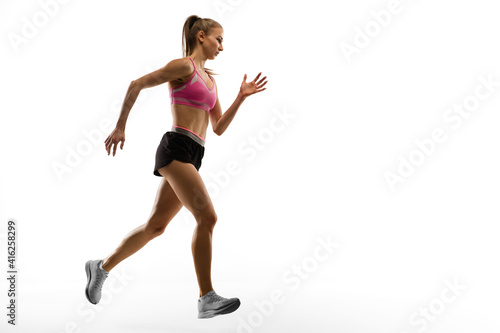 Strong. Caucasian professional female athlete, runner training isolated on white studio background. Muscular, sportive woman. Concept of action, motion, youth, healthy lifestyle. Copyspace for ad. © master1305