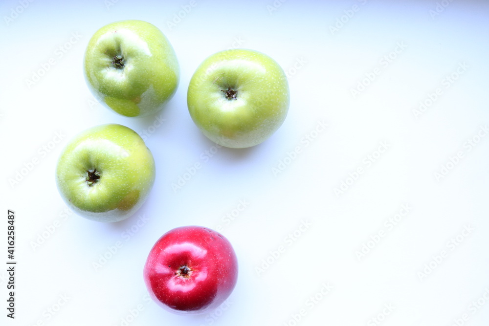 Three green and one red apples on a white background Three green and one red apples on a white background