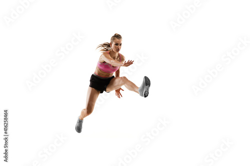 Fototapeta Naklejka Na Ścianę i Meble -  In jump. Caucasian professional female athlete, runner training isolated on white studio background. Muscular, sportive woman. Concept of action, motion, youth, healthy lifestyle. Copyspace for ad.