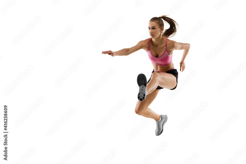 In jump. Caucasian professional female athlete, runner training isolated on white studio background. Muscular, sportive woman. Concept of action, motion, youth, healthy lifestyle. Copyspace for ad.