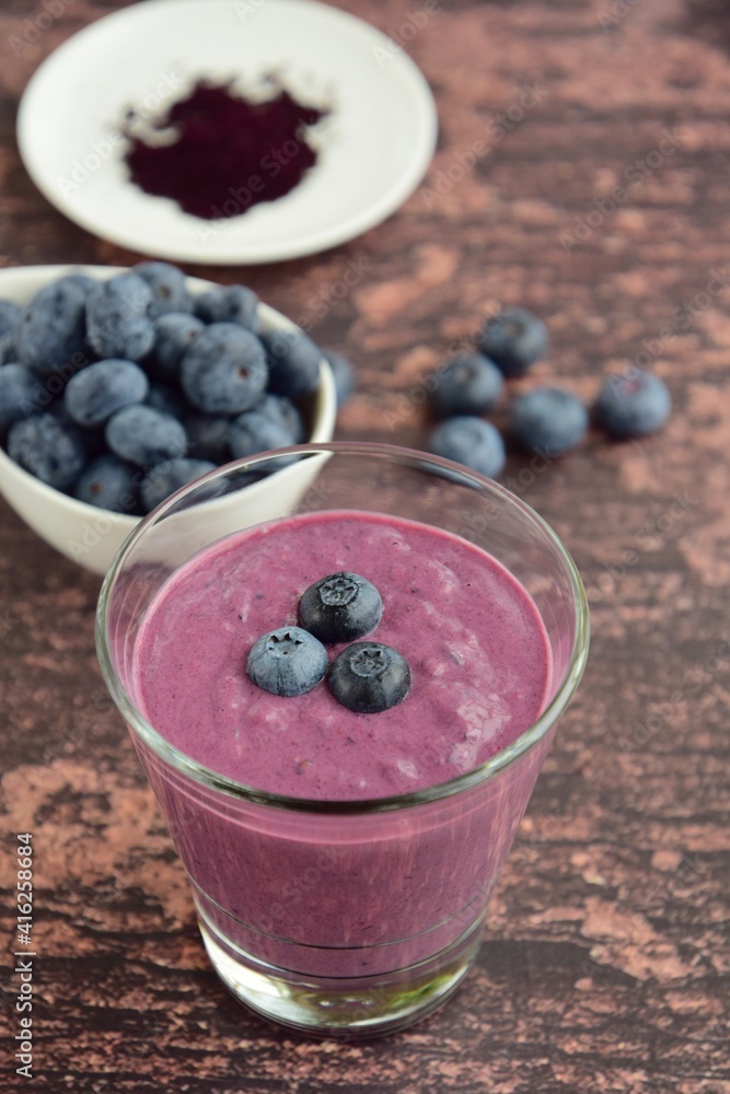 Fresh blueberry smoothie in a glass on wooden background. Selective focus Fresh blueberry smoothie in a glass on wooden background. Selective focus