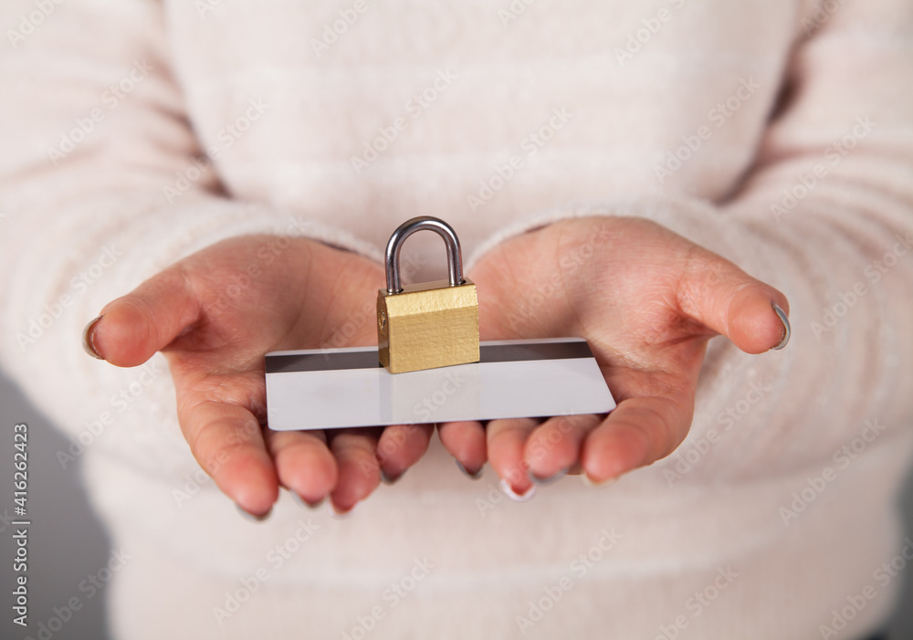 Obraz premium Padlock in a woman's hand, and credit card.