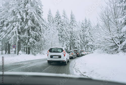 Traffic jam on a snow-covered road. Cars keep their distance.Family trip, vacation, adventure. Winter landscape. Driving a car in extreme winter conditions.Travel concept background © Elena