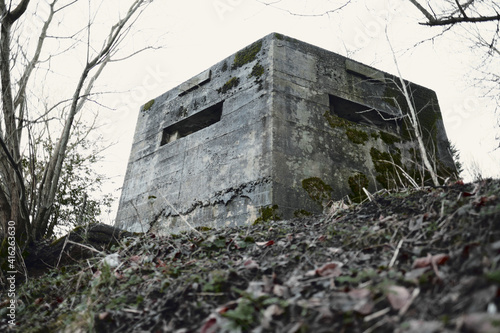 Fotografie A brutalist cold gritty concrete world war two, ww2, pillbox war bunker defence fortress in a dirty forgotten woodland in europe