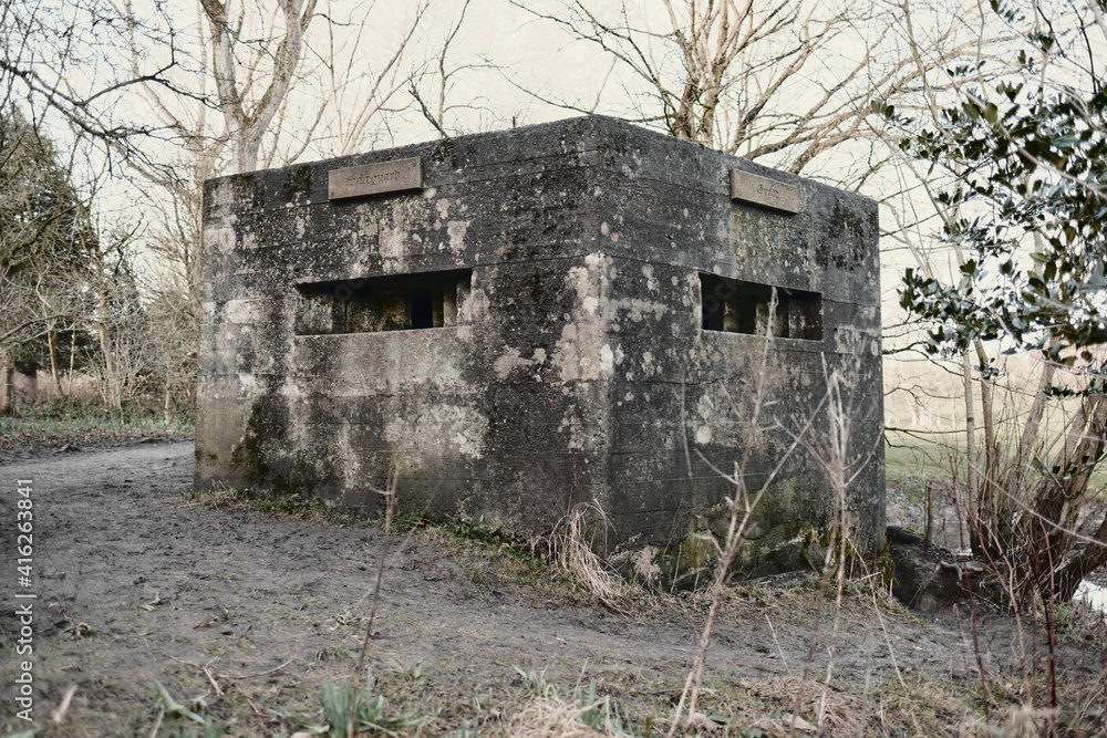 A brutalist cold gritty concrete world war two, ww2, pillbox war bunker defence fortress in a dirty forgotten woodland in europe. wartime relics and forgotten outpost using solid architecture A brutalist cold gritty concrete world war two, ww2, pillbox war bunker defence fortress in a dirty forgotten woodland in europe. wartime relics and forgotten outpost using solid architecture
